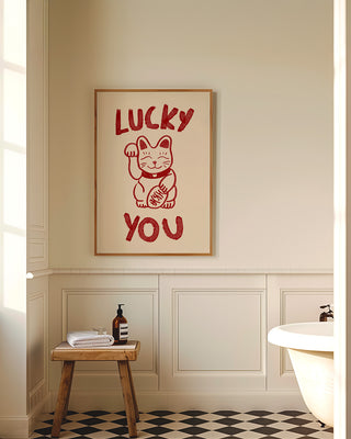 Lucky you unique wall art print in oak frame in modern bathroom. The art print is hand drawn and features a drawing of Japanese lucky cat. The poster is in cream and cherry red. Contemporary wall art gift for loved ones, anniversaries or Valentine's day.