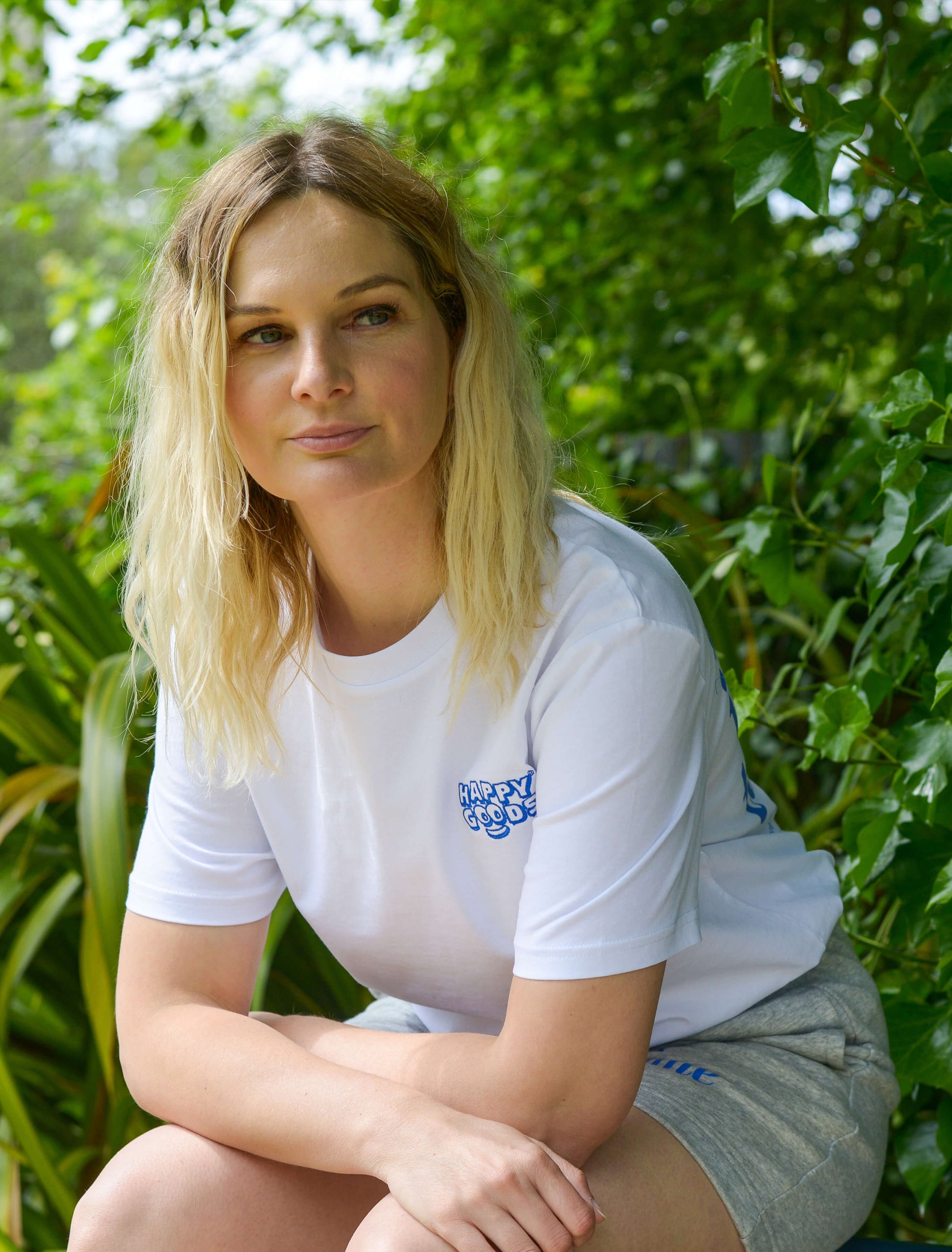 The best is yet to come t-shirt. positive messaging mental health tee. woman wearing t-shirt in nature sat on bench in park