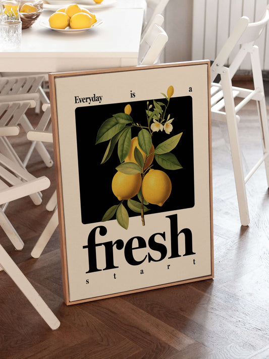 "Everyday is a fresh start" positive quote print in natural wooden frame in kitchen with bowls of lemons. The print features a vintage-inspired lemon illustration and classic bold fonts.