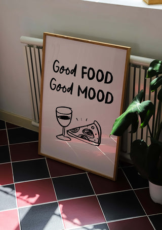 "Good Food Good Mood" art print for kitchens. Framed print on tiled floor with plant in situ.