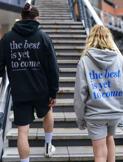 The best is yet to come hoodie. positive messaging mental health hoodie. Male and female models in matching clothing sets walking up stairs