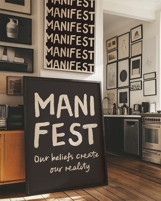 Manifest Print. Manifest poster. Black and cream manifestation art print. Large black framed print rests on floor of kitchen among various art. Spiritual poster