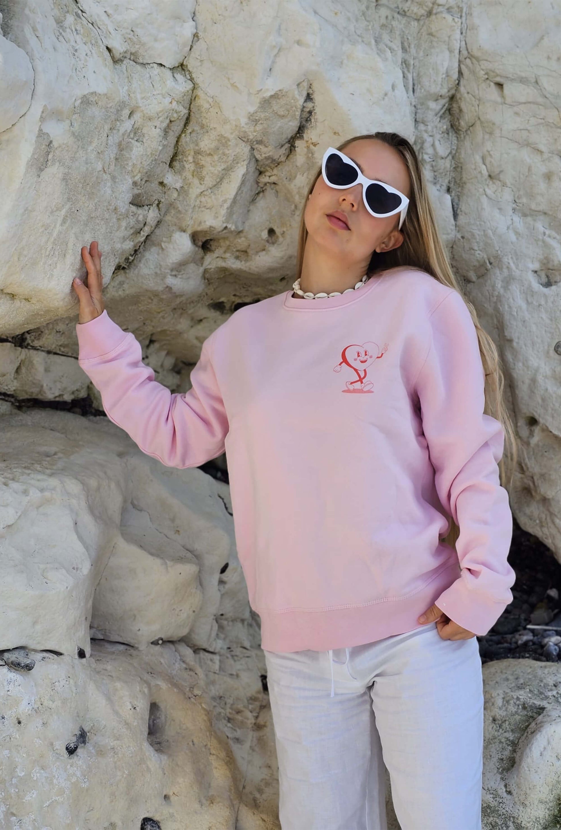 Pink positive sweater featuring heart mascot character