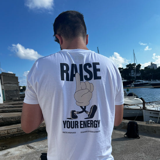Man wearing raise your energy t-shirt on holiday. High vibration clothing, community
